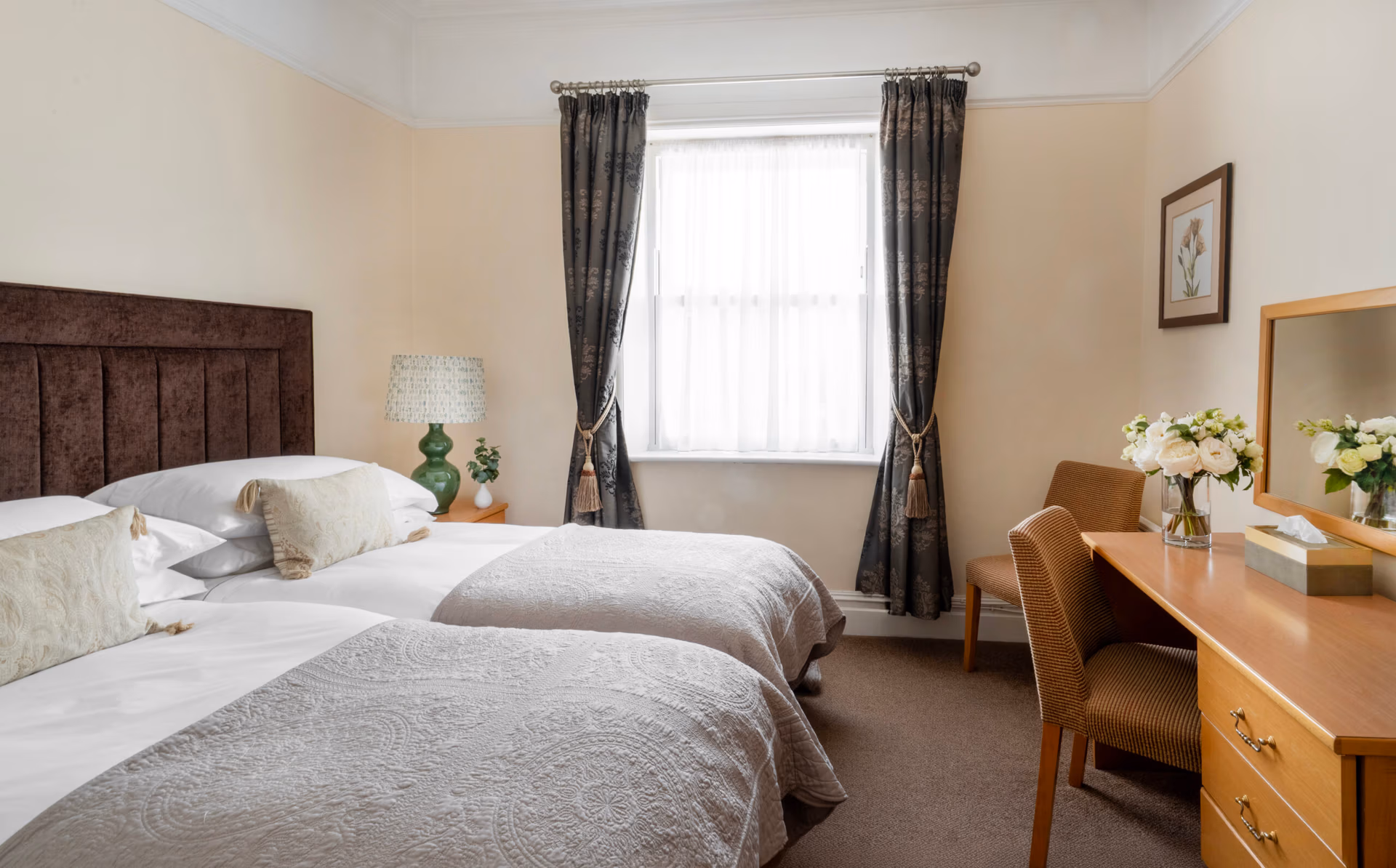 Two beds, a desk and chairs in a room