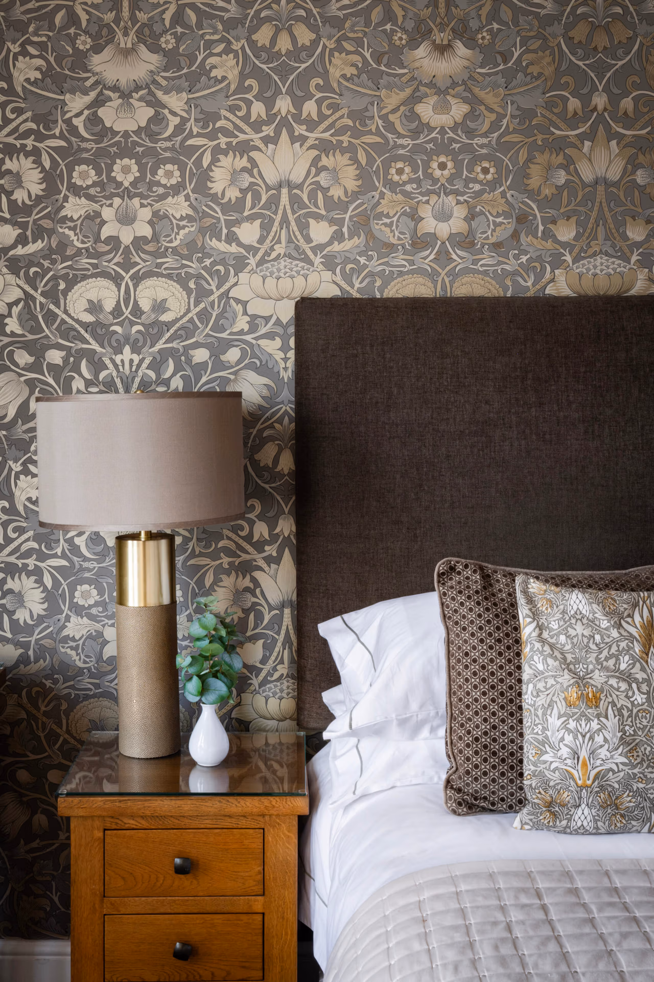 A bedside table with a lamp and plant