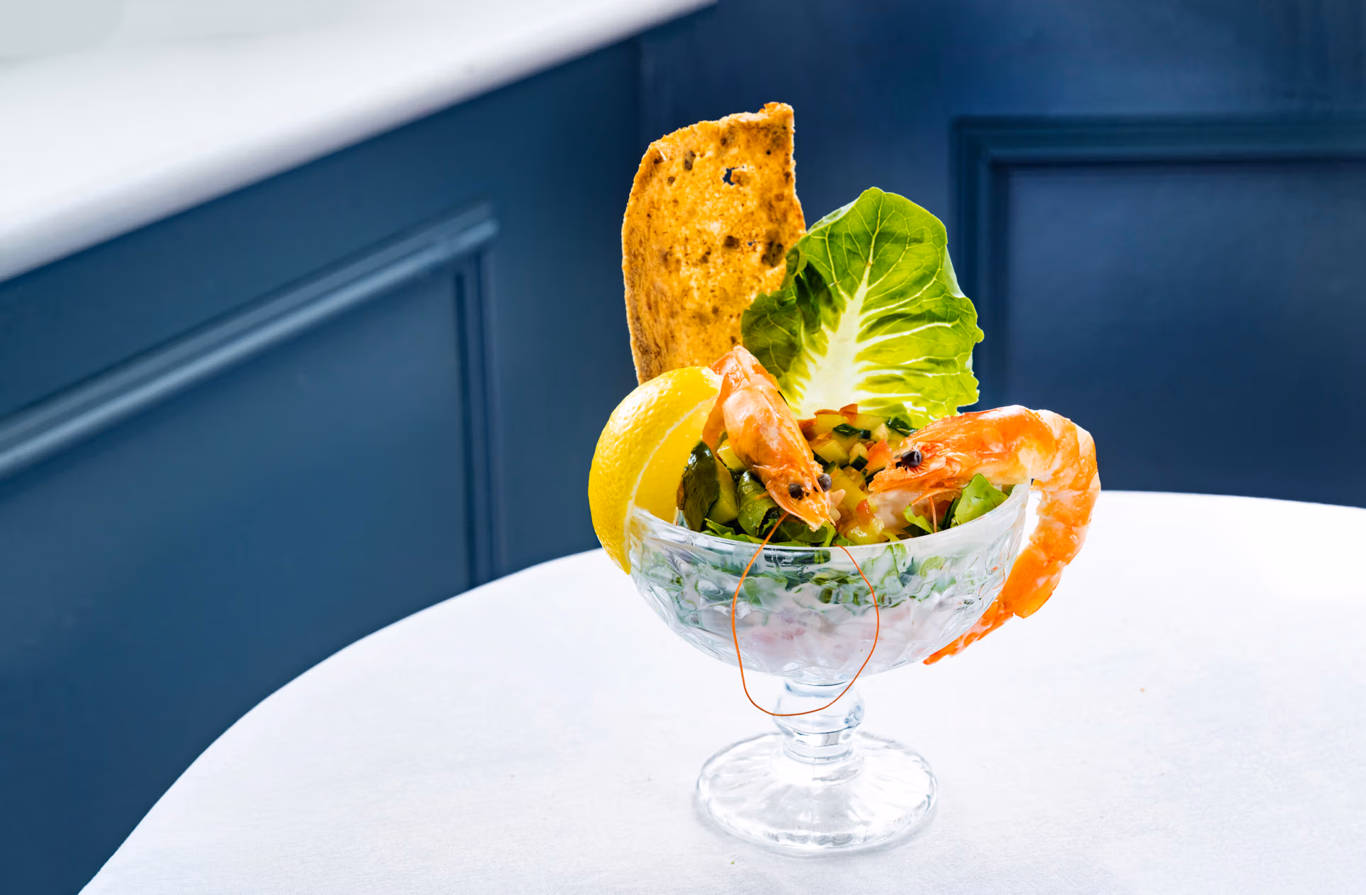 Prawn cocktail in a glass with a slice of lime and bread